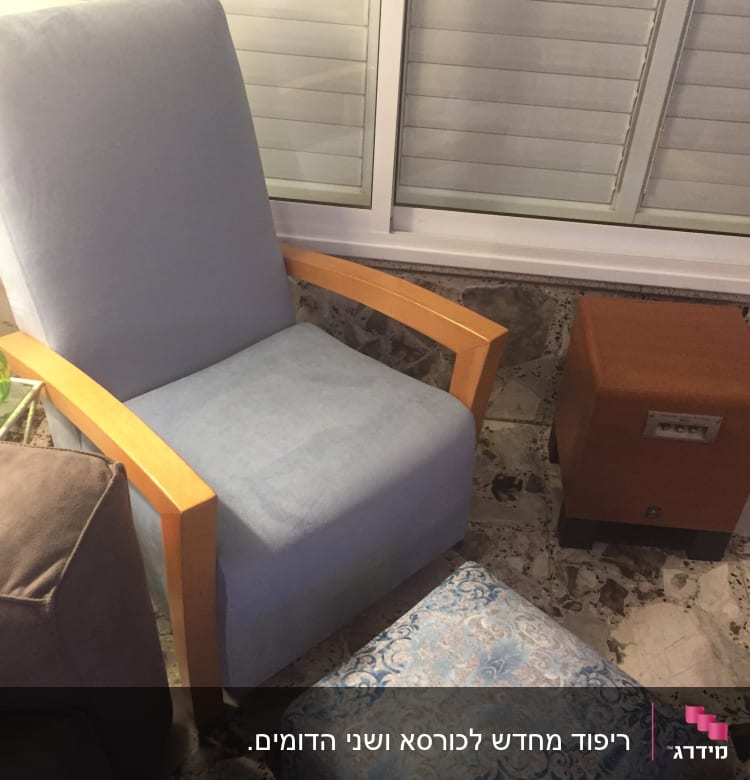 כורסה מרופדת עם הדום מרופד ליד שולחן קטן